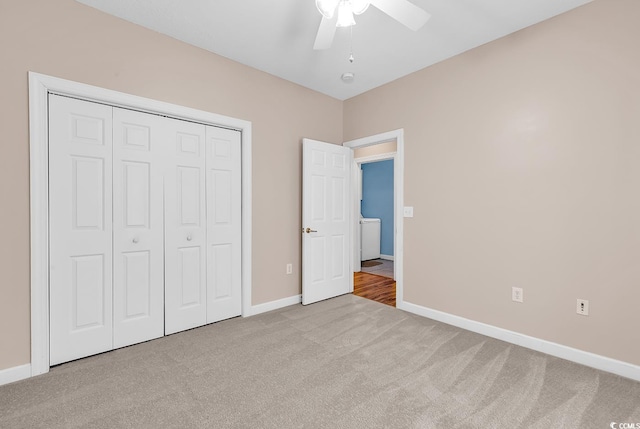 unfurnished bedroom featuring carpet floors, baseboards, ceiling fan, and a closet