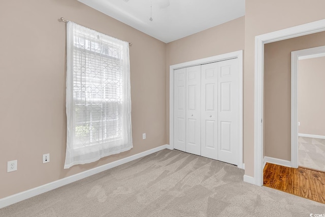 unfurnished bedroom featuring a closet, carpet, and baseboards