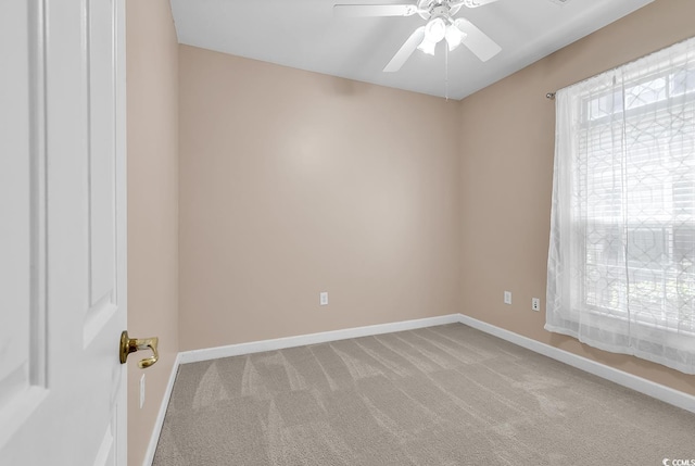 spare room featuring baseboards, ceiling fan, and carpet