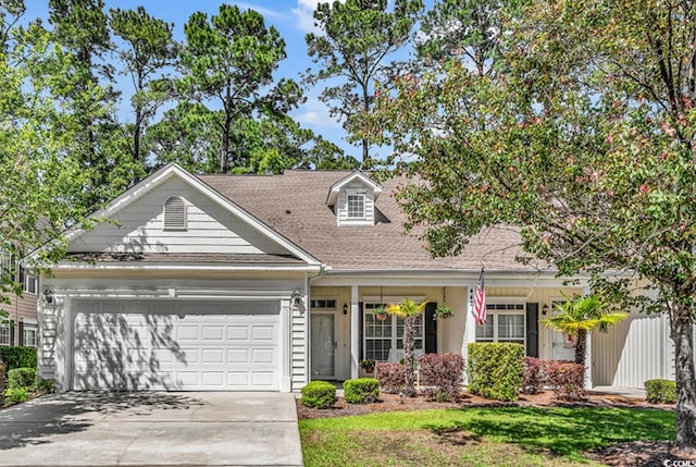 view of front of house with driveway, roof with shingles, and a garage