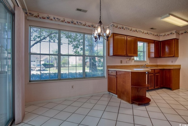 802 Mockingbird Ct, Murrells Inlet, SC 29576 - kitchen featuring a notable chandelier, a sink, light countertops, brown cabinetry, and visible vents