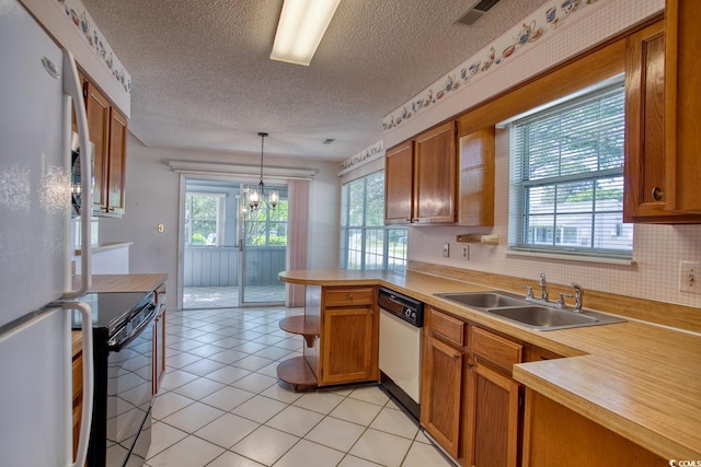 802 Mockingbird Ct, Murrells Inlet, SC 29576 - kitchen with brown cabinets, a sink, white appliances, light countertops, and a peninsula