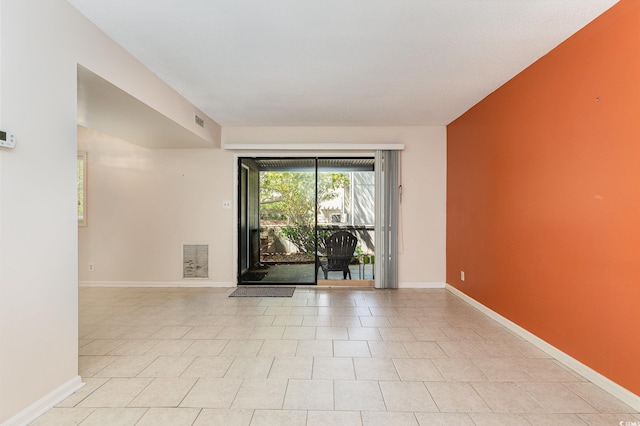 empty room featuring baseboards and visible vents