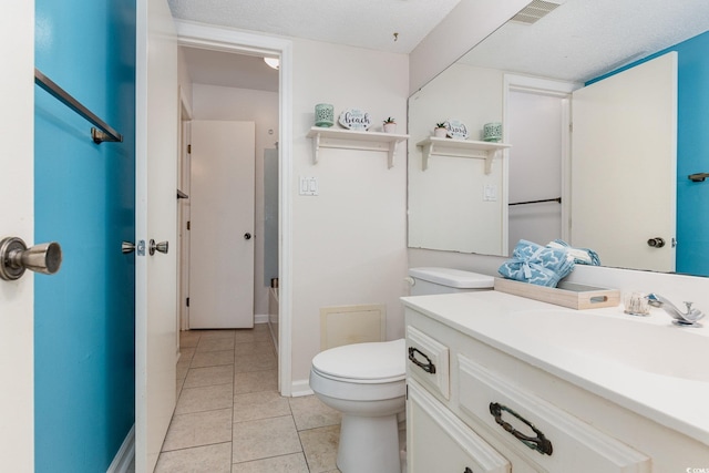 bathroom featuring vanity, toilet, tile patterned floors, a textured ceiling, and visible vents