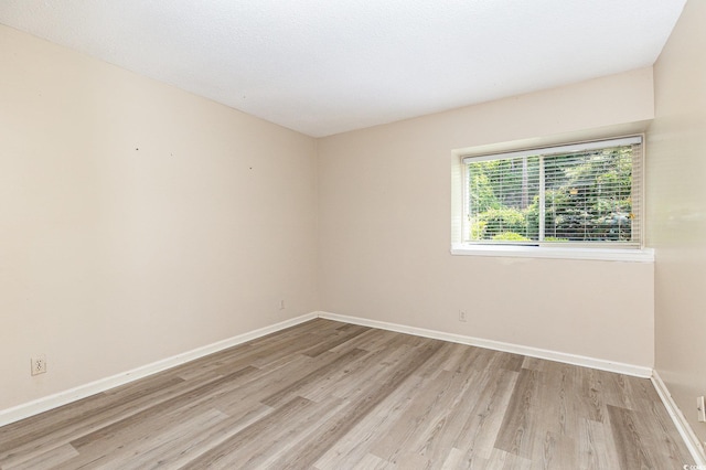unfurnished room with baseboards and wood finished floors