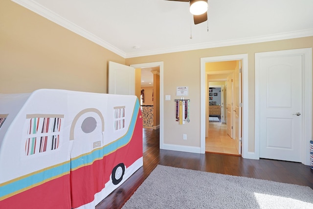 bedroom with baseboards, ceiling fan, ornamental molding, and wood finished floors
