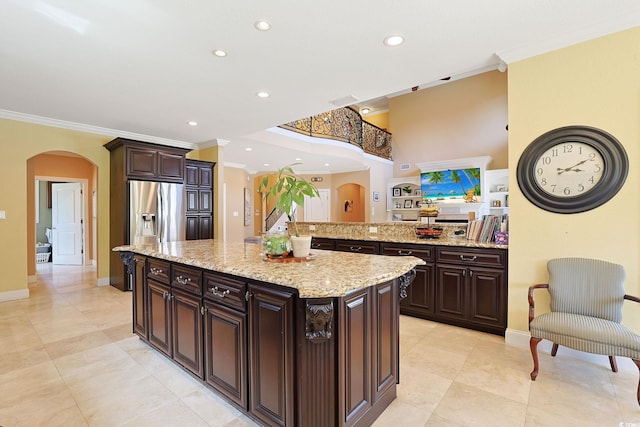 kitchen featuring stainless steel fridge, arched walkways, crown molding, and recessed lighting