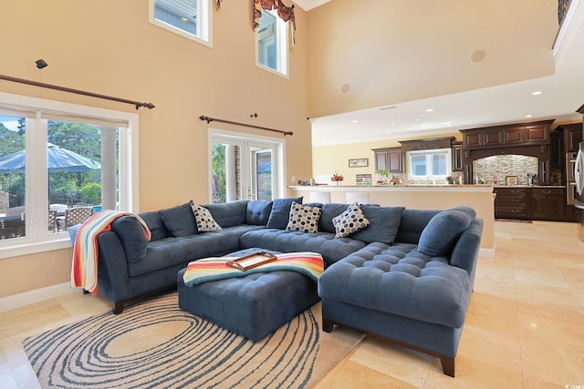 living room featuring baseboards, recessed lighting, a high ceiling, and light tile patterned flooring