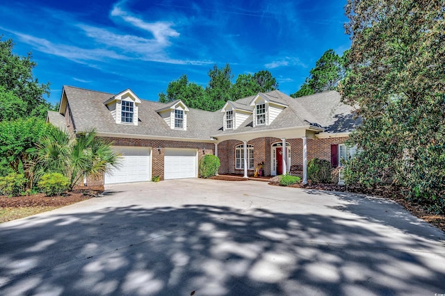 view of front of house featuring covered porch, roof with shingles, brick siding, concrete driveway, and an attached garage