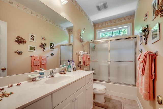 full bath with visible vents, vanity, toilet, tile patterned floors, and enclosed tub / shower combo