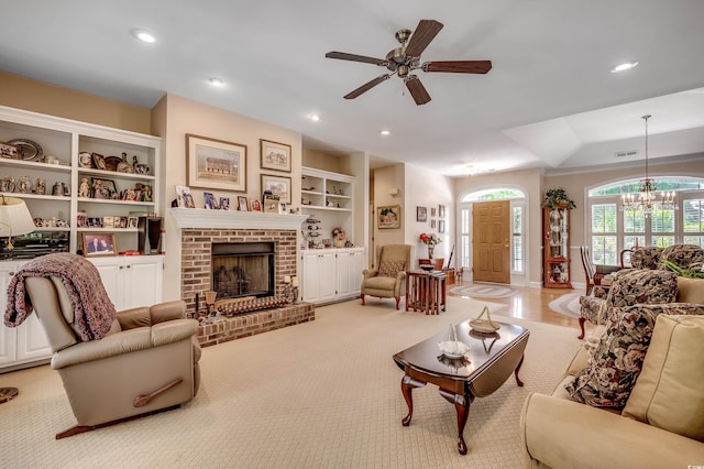 carpeted living area featuring a fireplace, built in shelves, ceiling fan with notable chandelier, recessed lighting, and visible vents