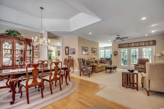 dining room with light carpet, light wood finished floors, ceiling fan with notable chandelier, recessed lighting, and baseboards
