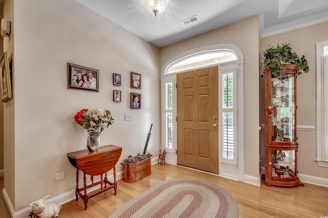 foyer entrance with visible vents, light wood finished floors, and baseboards