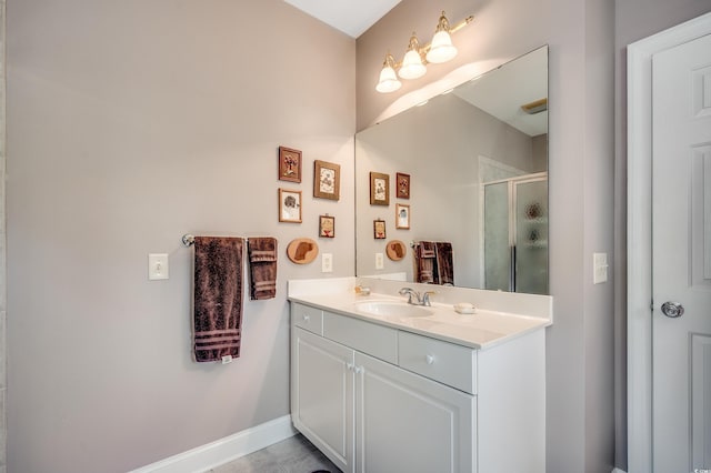 bathroom featuring vanity, baseboards, and a shower stall