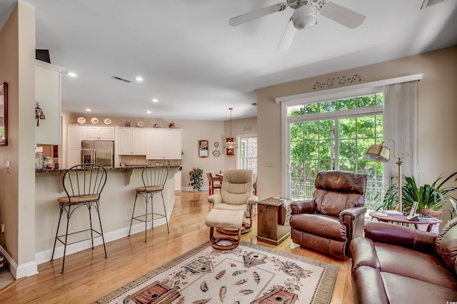 living area featuring a ceiling fan, recessed lighting, light wood-style flooring, and visible vents