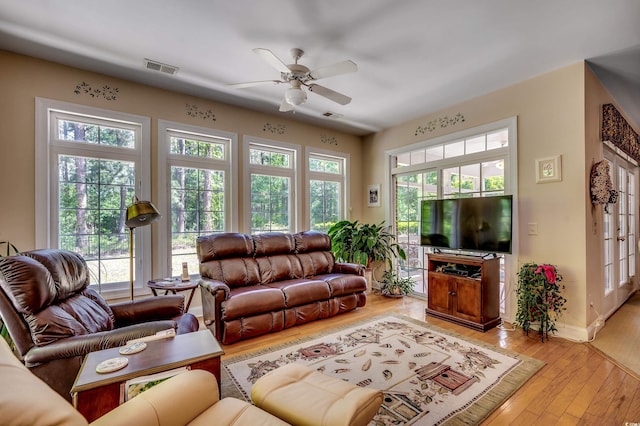 living area with visible vents, ceiling fan, a healthy amount of sunlight, and light wood-type flooring