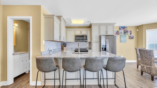 324 S Waccamaw Dr, Garden City Beach, SC 29576 - kitchen featuring light wood finished floors, a peninsula, light stone countertops, backsplash, and appliances with stainless steel finishes