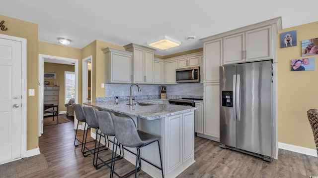 324 S Waccamaw Dr, Garden City Beach, SC 29576 - kitchen with a sink, a kitchen breakfast bar, a peninsula, tasteful backsplash, and appliances with stainless steel finishes