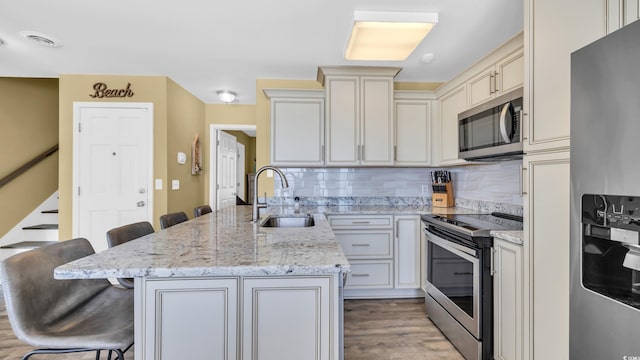 324 S Waccamaw Dr, Garden City Beach, SC 29576 - kitchen with a sink, a peninsula, stainless steel appliances, backsplash, and a kitchen bar