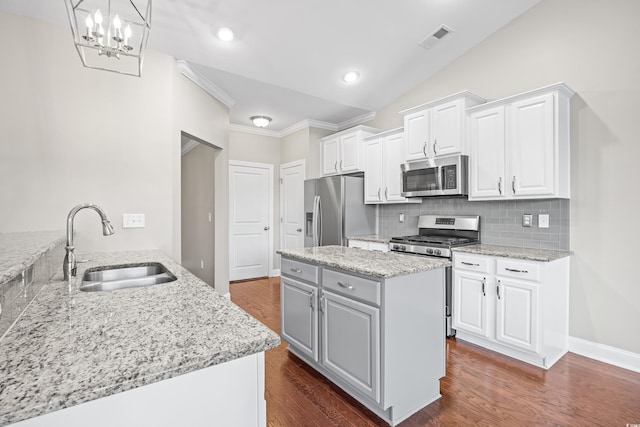 kitchen with a sink, stainless steel appliances, backsplash, visible vents, and ornamental molding