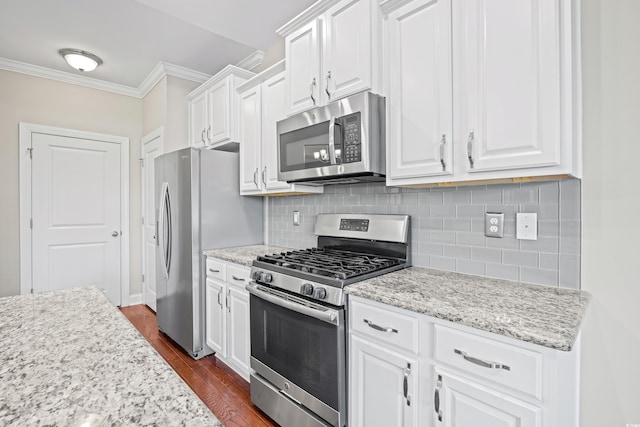 kitchen with crown molding, dark wood-style flooring, white cabinets, appliances with stainless steel finishes, and backsplash