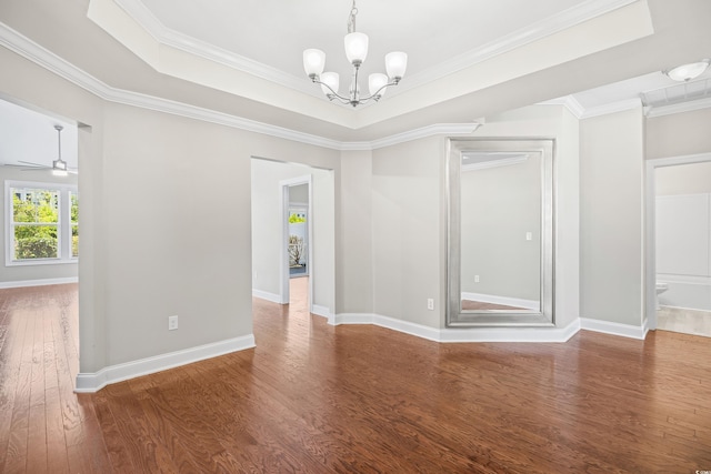 unfurnished room with wood finished floors, a raised ceiling, baseboards, ceiling fan with notable chandelier, and ornamental molding