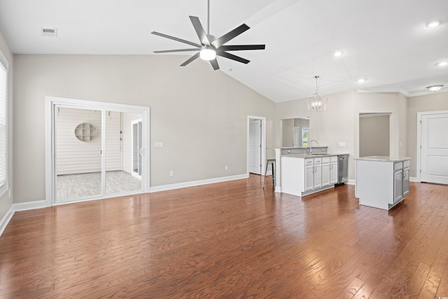 unfurnished living room with dark wood-type flooring, a sink, ceiling fan with notable chandelier, and lofted ceiling
