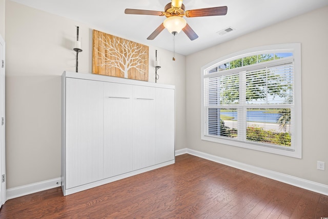 spare room featuring visible vents, baseboards, and wood finished floors