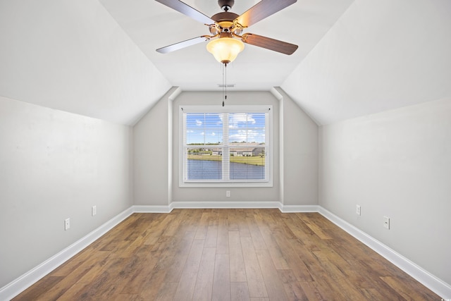 additional living space featuring ceiling fan, visible vents, baseboards, wood finished floors, and vaulted ceiling