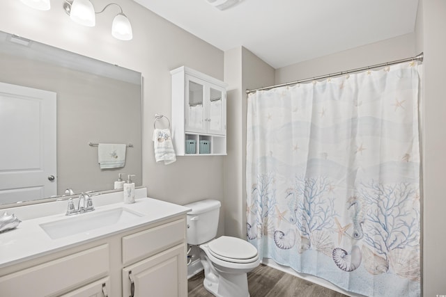 full bathroom featuring vanity, a shower with shower curtain, wood finished floors, and toilet