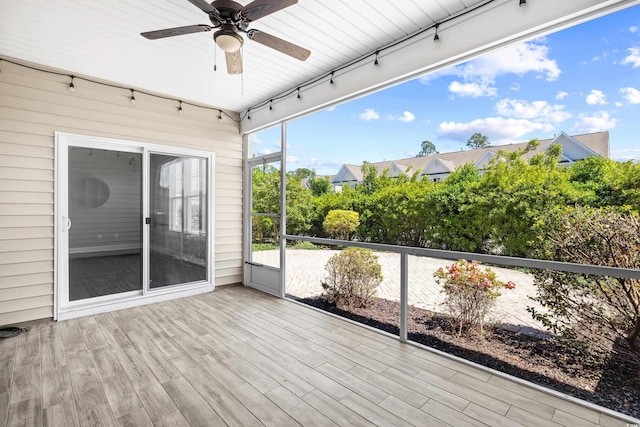 unfurnished sunroom with track lighting and a ceiling fan