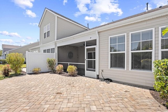 back of house with a sunroom, ceiling fan, fence, and a patio area