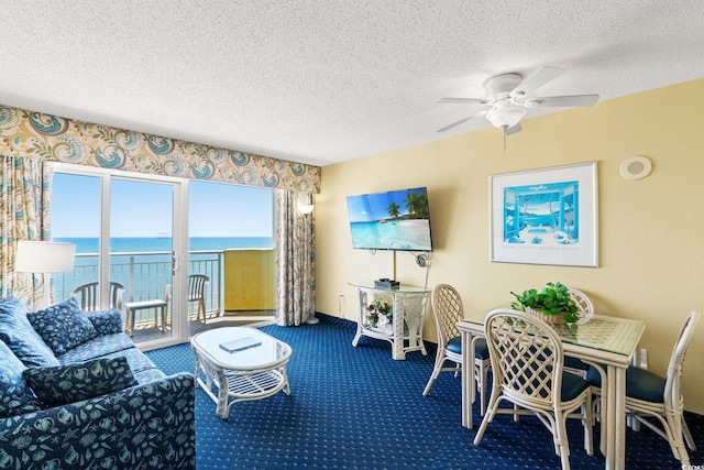 carpeted living room featuring a textured ceiling, ceiling fan, and baseboards