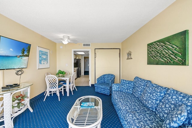 carpeted living room with a ceiling fan