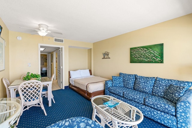 carpeted living room featuring ceiling fan and a textured ceiling