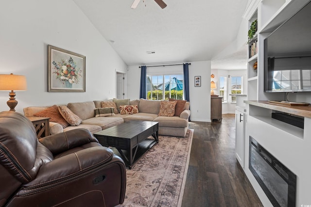 living area featuring a ceiling fan, dark wood-style flooring, vaulted ceiling, and a healthy amount of sunlight