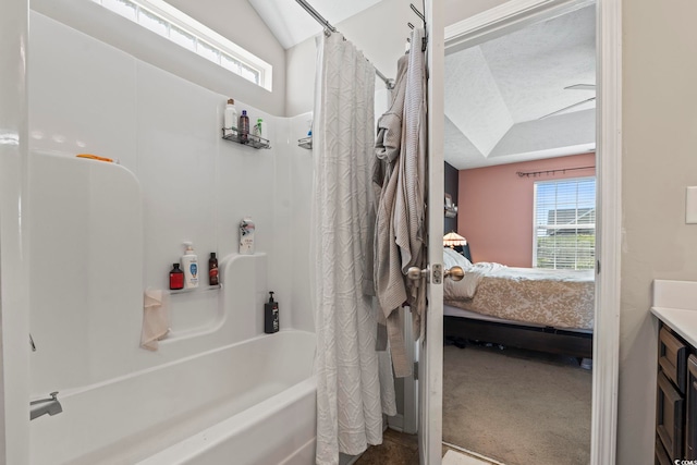 ensuite bathroom featuring connected bathroom, vanity, and shower / tub combo