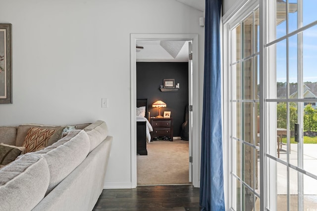 hallway with baseboards, plenty of natural light, and dark wood-style flooring