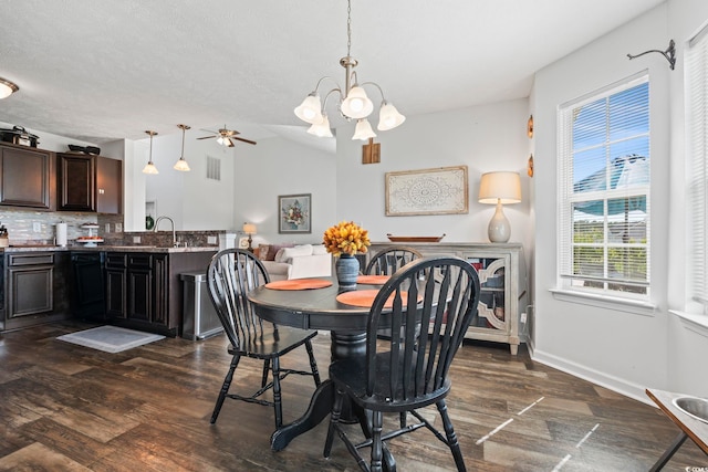 dining area with dark wood-style flooring, ceiling fan with notable chandelier, baseboards, lofted ceiling, and visible vents