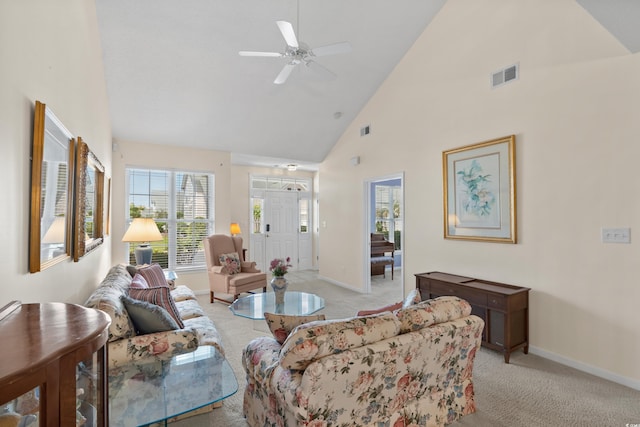 living area with light colored carpet, baseboards, visible vents, and high vaulted ceiling