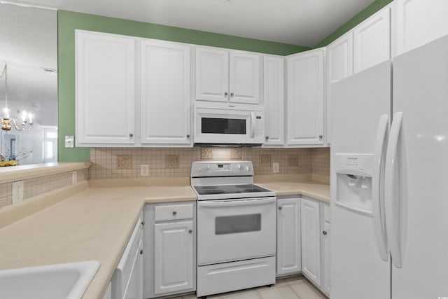 kitchen with light countertops, white cabinets, white appliances, and tasteful backsplash