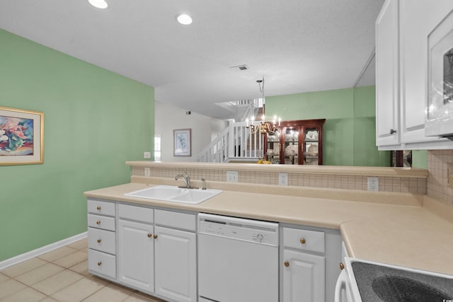 kitchen with an inviting chandelier, a sink, backsplash, and dishwasher