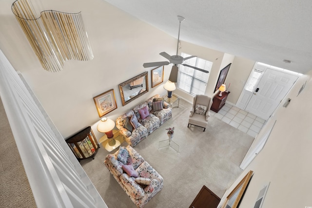 living room featuring carpet floors, a ceiling fan, and tile patterned floors