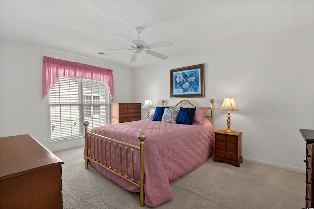 carpeted bedroom with baseboards, a ceiling fan, a textured ceiling, and visible vents