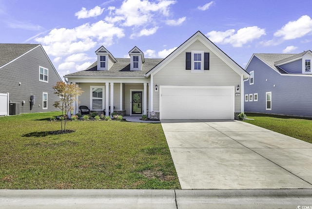 view of front of home featuring an attached garage, a front lawn, driveway, and covered porch