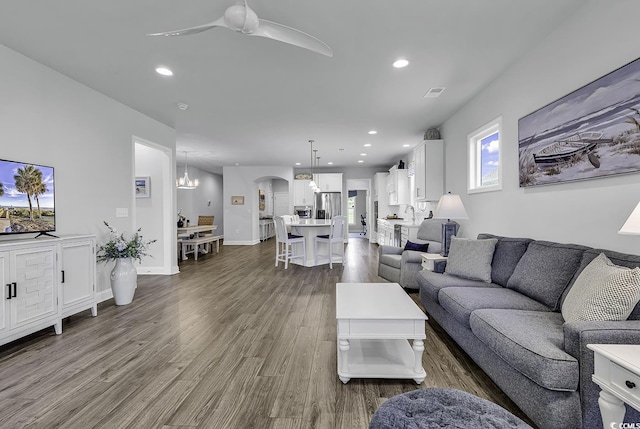 living area with dark wood-style flooring, arched walkways, a ceiling fan, recessed lighting, and visible vents
