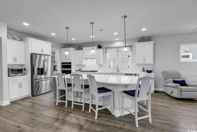 kitchen with stainless steel refrigerator with ice dispenser, a sink, a healthy amount of sunlight, and visible vents