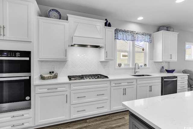 kitchen with white cabinets, a sink, stainless steel appliances, recessed lighting, and decorative backsplash