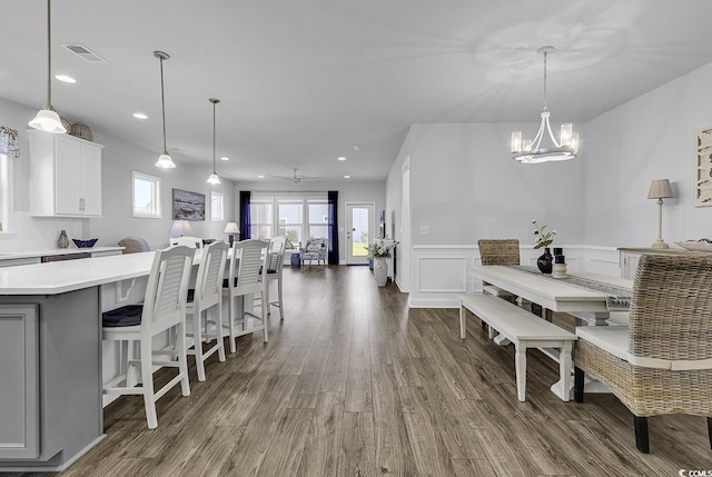 dining area with visible vents, wood finished floors, a wainscoted wall, a chandelier, and recessed lighting
