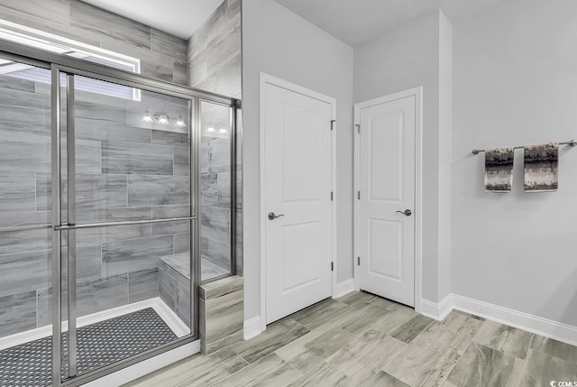 bathroom with baseboards and a stall shower